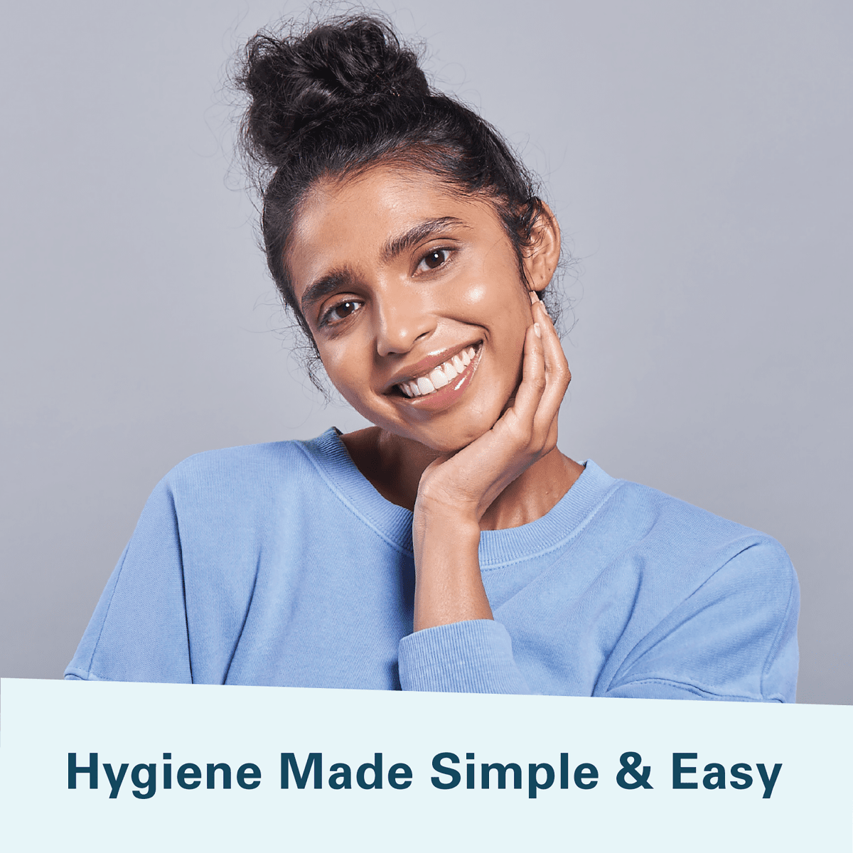 Woman smiling in a blue shirt with text 'Hygiene Made Simple & Easy' on a gray background.
