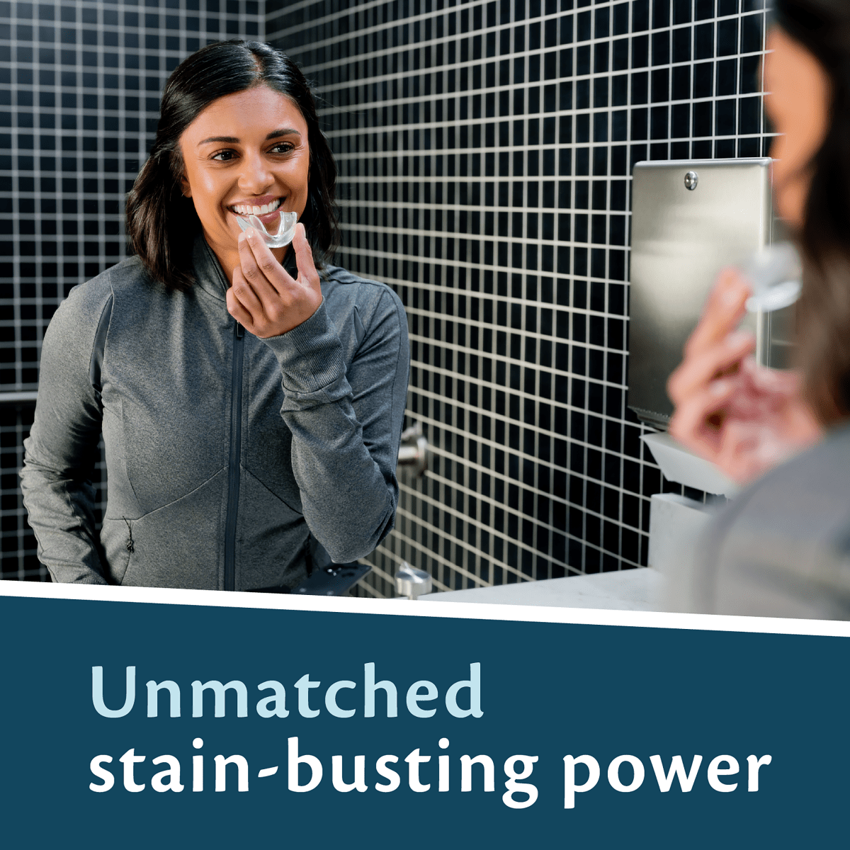 Woman applying a dental guard in a bathroom with text about stain-busting power.