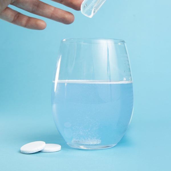 Glass of water with dental cleaning tablet.