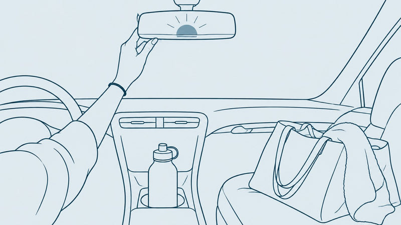 Hand on rearview mirror, bottle in cup holder