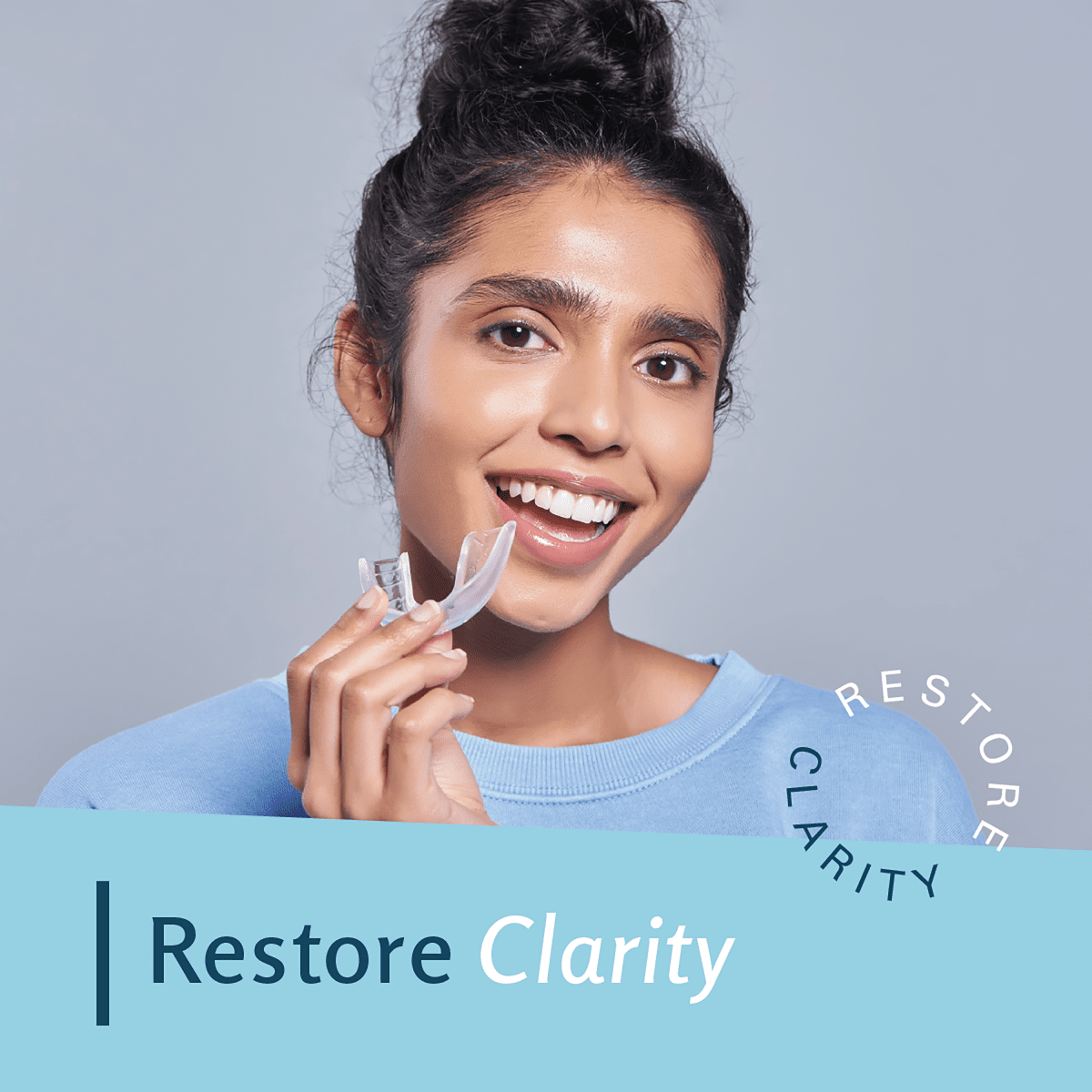 Woman holding a clear aligner with 'Restore Clarity' text.